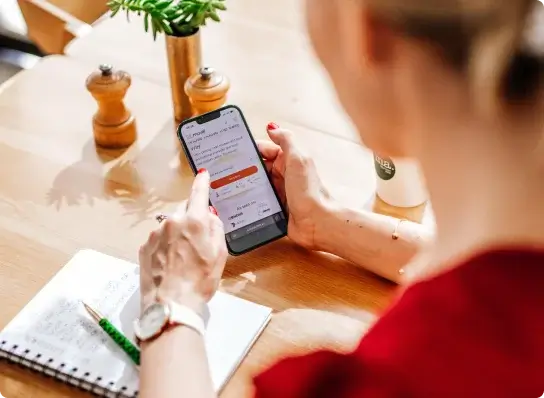 Looking over the shoulder of a woman booking a move on her phone