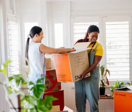 Two women packing Muval moving boxes