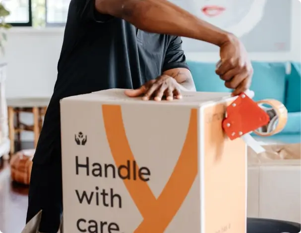 Removalist taping up a moving box