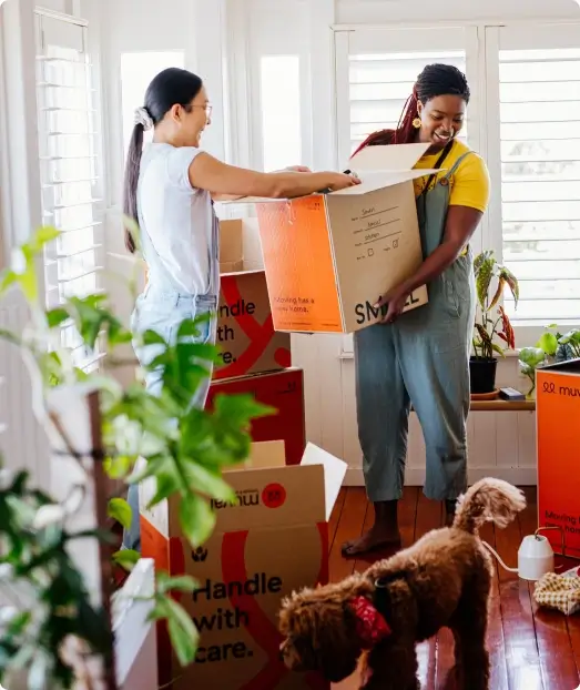 Two women packing moving boxes